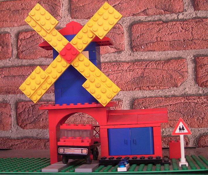 A small windmill with a truck and a sign made with LEGO